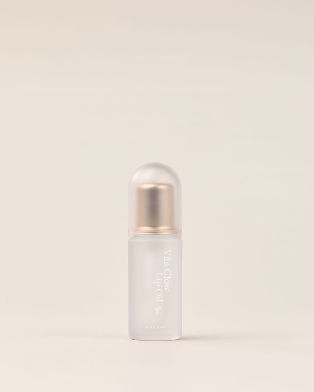 AXIS-Y Vita Glow Lip Oil Lipgloss mit pflegender Textur in einem transparenten Flakon, auf einem weißen Hintergrund liegend